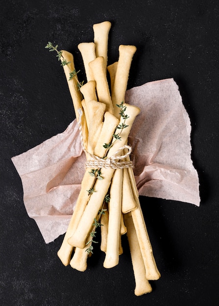 Photo gratuite vue de dessus de grissini avec tissu et herbes