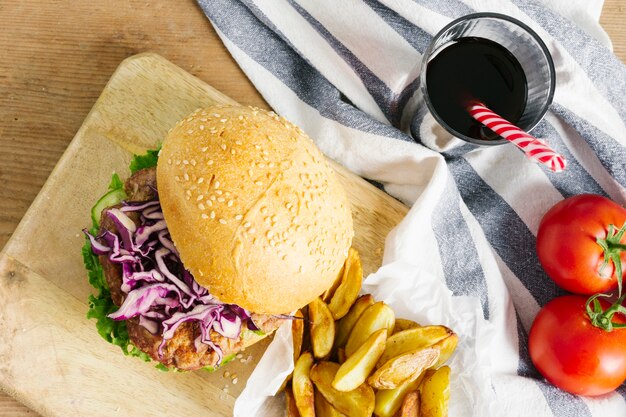 Vue de dessus gros plan de burger et frites sur une planche de bois