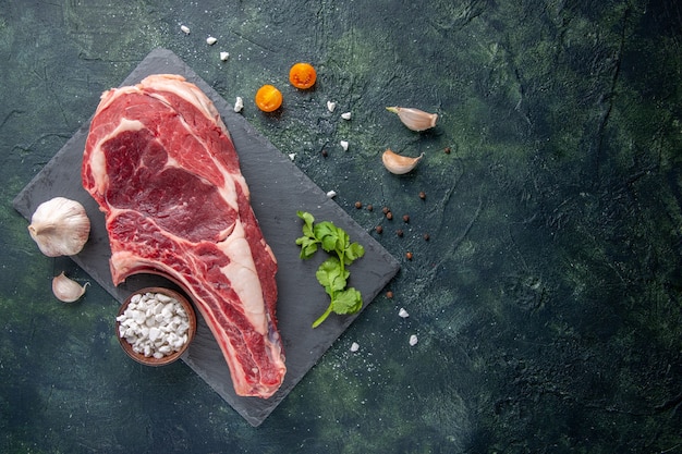 Vue de dessus grosse tranche de viande viande crue sur une surface sombre