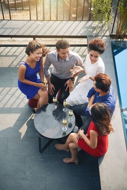 Vue de dessus d'un groupe d'amis assis autour d'une table lors d'une fête en plein air