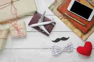 Photo gratuite vue de dessus happy father day with travel.airplane et passeport sur fond de bois rustique.accessoires avec, carte, moustache, cravate vintage, stylo, cadeau, coeur rouge, téléphone portable et cahier blanc.