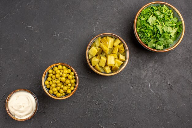 Vue de dessus des haricots et légumes verts différents ingrédients de la salade sur une surface sombre