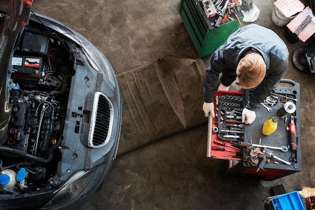 Vue de dessus homme réparant une voiture