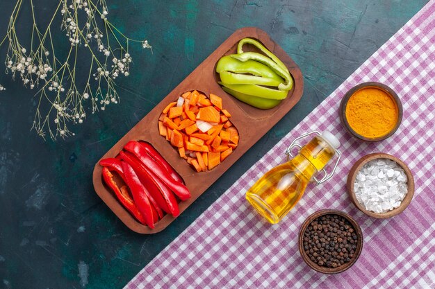 Vue de dessus de l'huile d'olive avec différents assaisonnements et salade sur fond bleu foncé ingrédient produit alimentaire photo