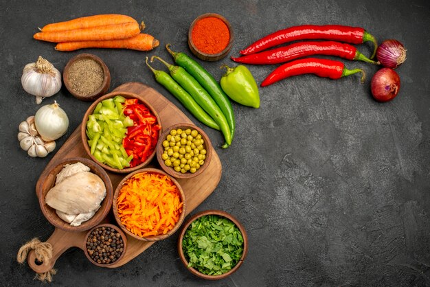 Vue de dessus des ingrédients de la salade fraîche avec des assaisonnements sur la couleur des aliments de repas de salade de table sombre