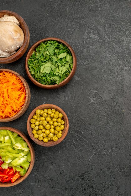 Vue de dessus des ingrédients de la salade avec des légumes verts et du poulet sur une salade de santé diététique de table sombre