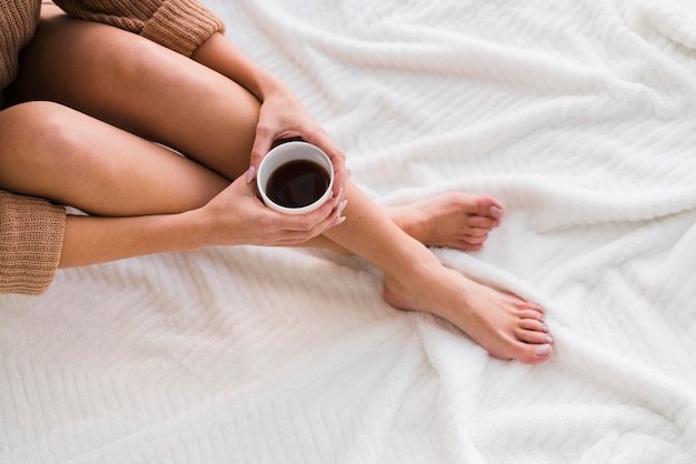 Photo gratuite vue de dessus des jambes et une tasse de café