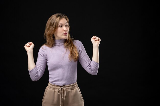 Vue de dessus d'une jeune femme confiante profitant de son succès et regardant quelque chose dans l'obscurité