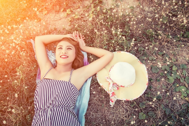 Photo gratuite vue de dessus jeune femme couchée près de son chapeau