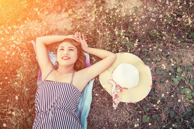 Vue de dessus jeune femme couchée près de son chapeau