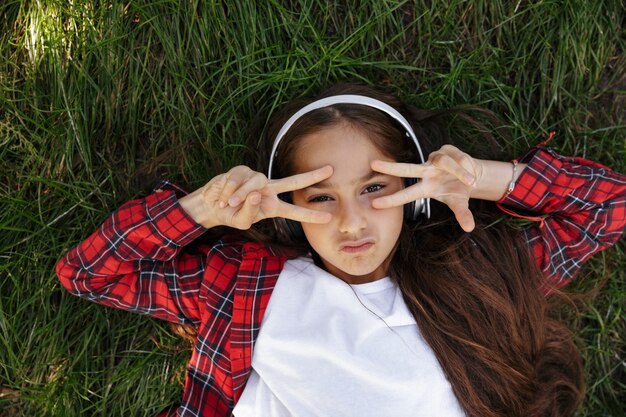 Vue de dessus de la jeune fille brune allongée sur l'herbe