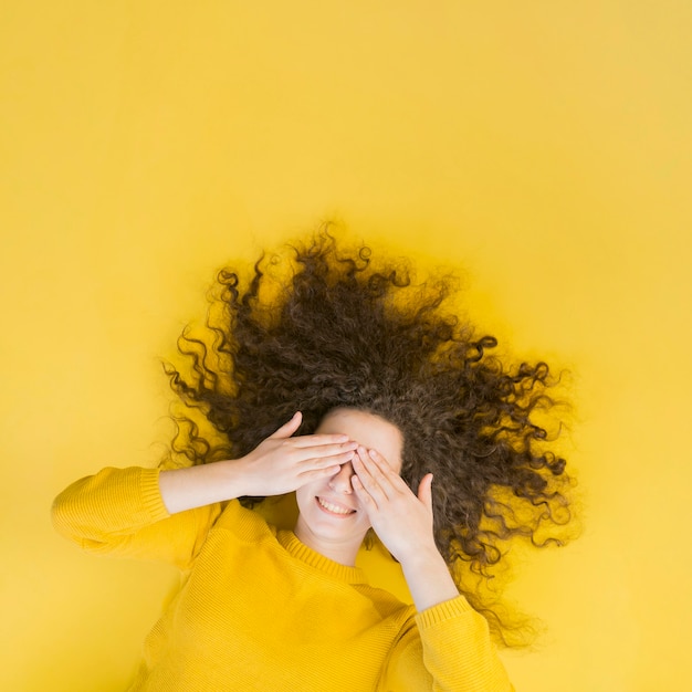 Vue de dessus jeune fille couvrant son visage