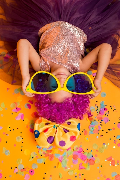 Photo gratuite vue de dessus de jolie fille avec de grandes lunettes de soleil et des confettis
