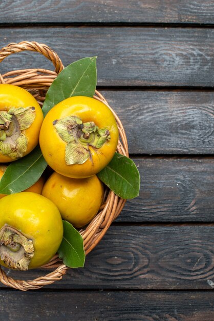 Vue de dessus kakis frais fruits sucrés mûrs sur plancher rustique en bois fruit doux