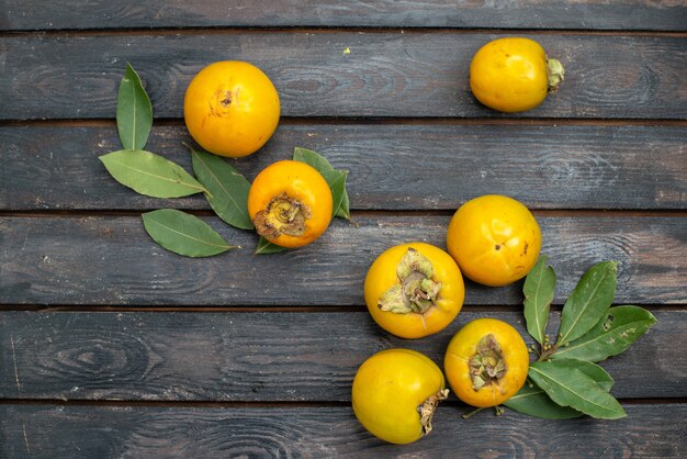 Vue de dessus kakis frais sur table rustique en bois, fruits mûrs moelleux