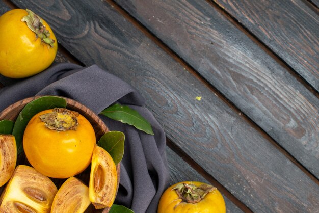 Vue de dessus kakis sucrés frais sur une table en bois, fruits mûrs moelleux