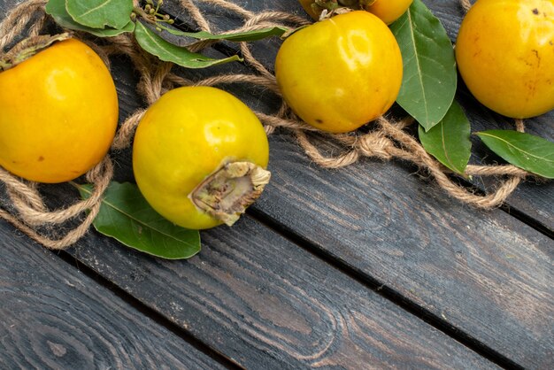 Vue de dessus kakis sucrés frais sur une table en bois, goût de fruits mûrs