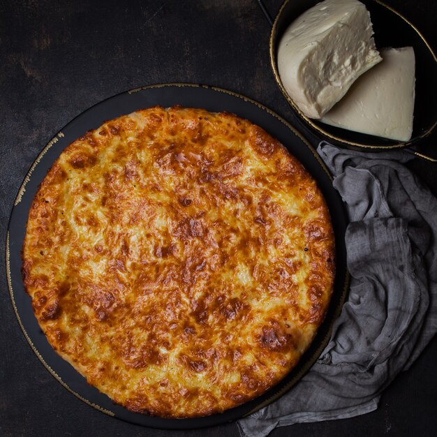 Vue de dessus khachapuri avec fromage sulguni en plaque sombre