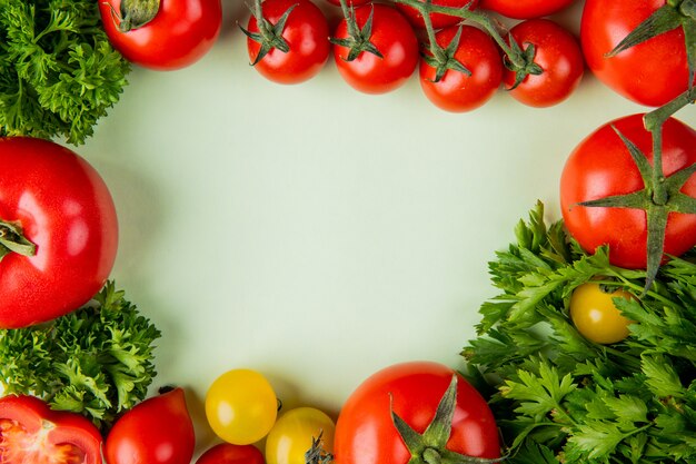 Vue de dessus des légumes comme la coriandre et la tomate sur une surface blanche avec copie espace