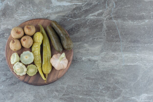 Vue de dessus des légumes en conserve sur planche de bois.