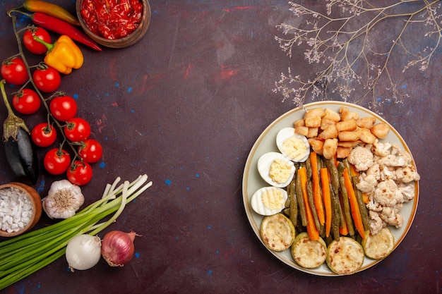 Vue de dessus légumes cuits avec repas aux œufs et légumes frais sur un espace sombre