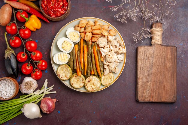 Vue de dessus légumes cuits avec repas aux œufs et légumes frais sur sol sombre repas repas déjeuner produit végétal