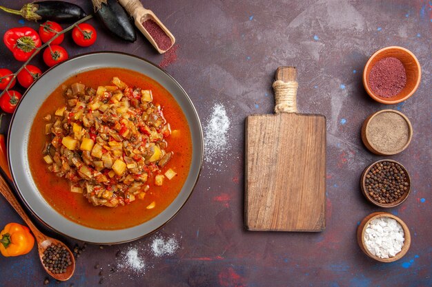 Vue de dessus légumes cuits tranchés avec de la sauce et des assaisonnements sur le fond sombre repas repas dîner soupe sauce légumes