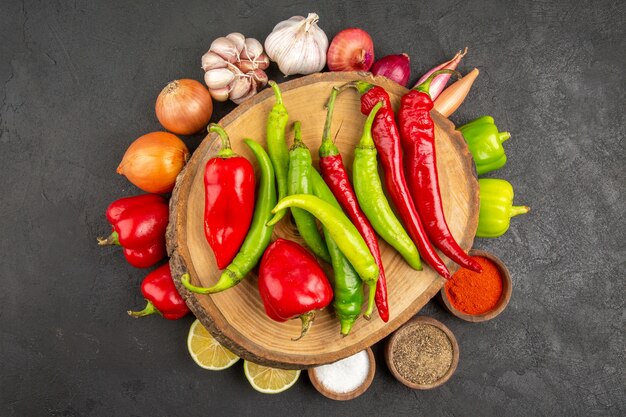 Vue de dessus des légumes frais avec assaisonnements et poivrons sur fond gris