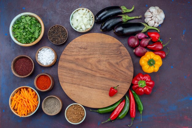 Vue de dessus des légumes frais avec des assaisonnements et des verts sur le bureau sombre salade alimentaire repas collation de légumes