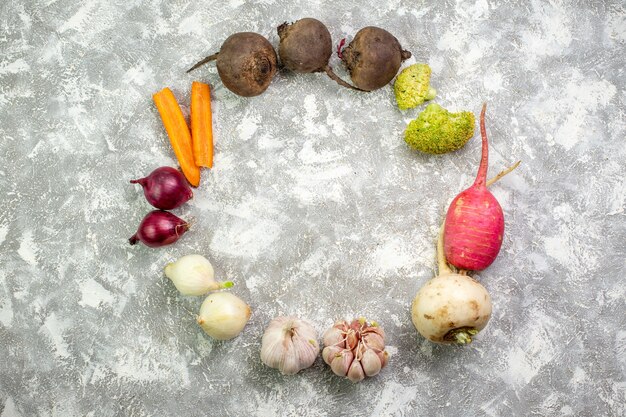 Vue de dessus légumes frais betterave radis ail et oignons sur tableau blanc