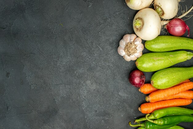 Vue de dessus des légumes frais bordés sur fond sombre