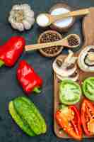 Photo gratuite vue de dessus légumes frais champignons tomates rouges et vertes poivrons rouges sur planche à découper