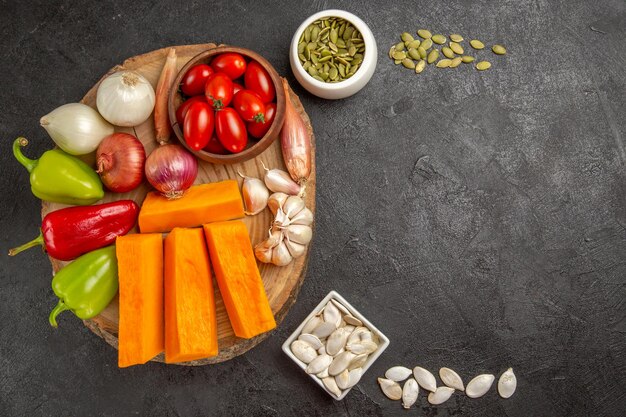 Vue de dessus des légumes frais à la citrouille sur fond gris foncé repas de couleur mûre salade fraîche