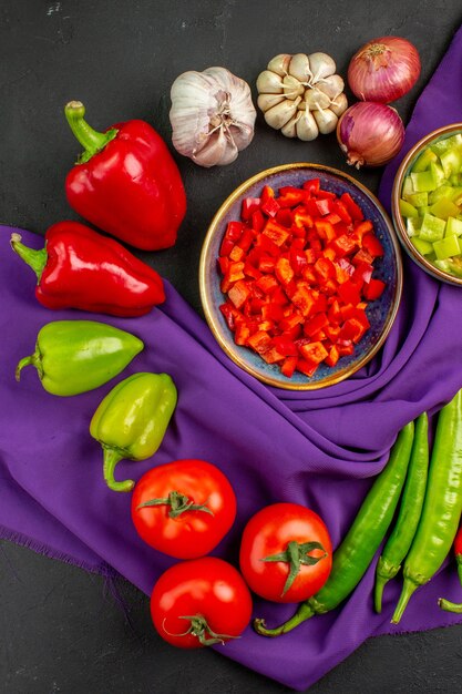 Photo gratuite vue de dessus des légumes frais avec du poivre et de l'ail sur une salade de table sombre couleur repas mûr