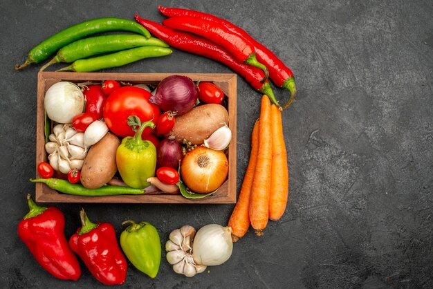 Vue de dessus des légumes frais avec du poivre et de l'ail sur la table sombre de la santé de la couleur de la salade mûre