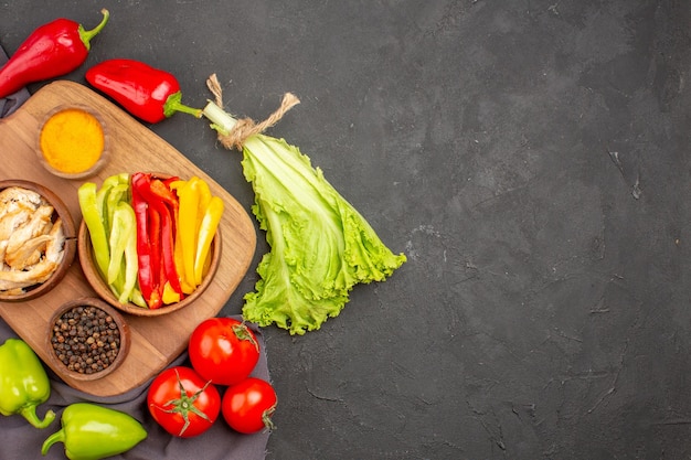 Vue de dessus des légumes frais mûrs avec assaisonnements sur fond noir