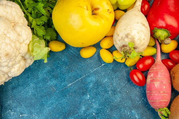 Vue de dessus légumes frais poivrons coing cumcuats chou-fleur sur fond bleu