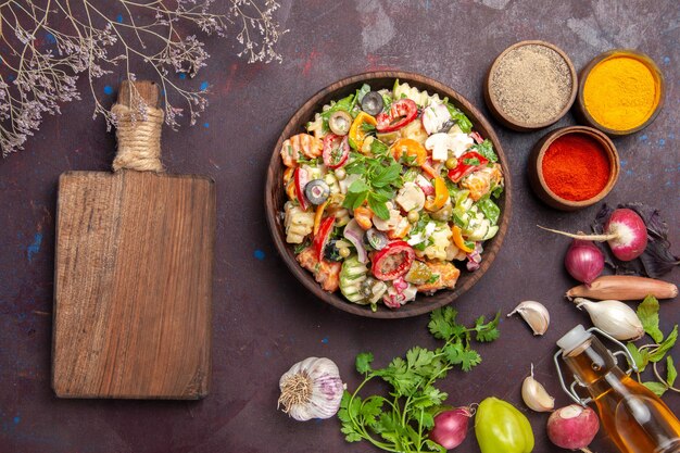 Vue de dessus de légumes frais. salade avec différents assaisonnements sur fond noir