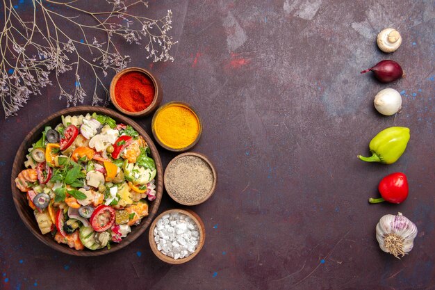 Vue de dessus de légumes frais. salade avec différents assaisonnements sur fond noir