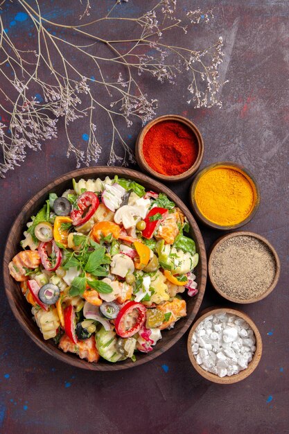 Vue de dessus de légumes frais. salade avec différents assaisonnements sur fond noir