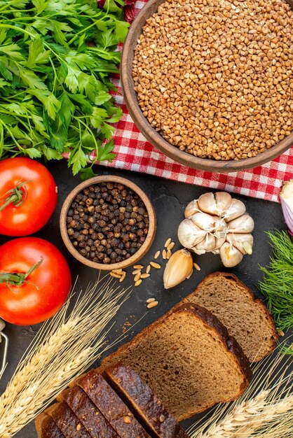 Vue de dessus des légumes frais sarrasin dans un bol brun sur des pointes de serviette dépouillées rouges tranches de pain vert