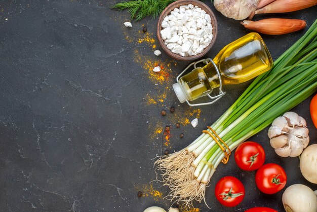 Vue de dessus des légumes frais sel de mer dans une petite bouteille d'huile de bol sur un espace libre de table sombre