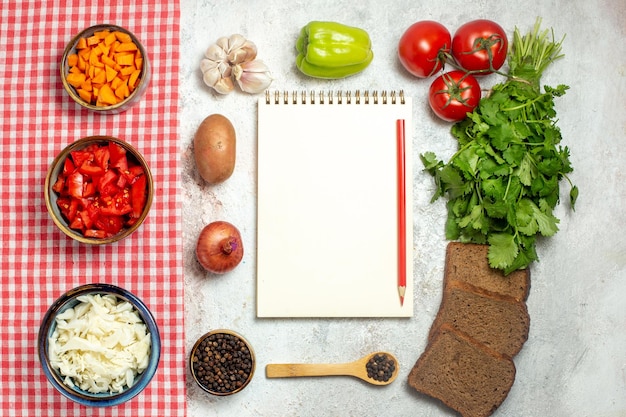 Photo gratuite vue de dessus légumes frais tomates poivrons et choux sur un espace blanc clair