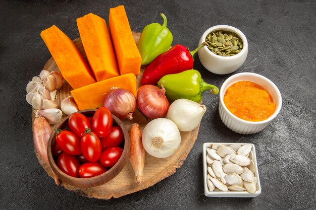 Vue de dessus des légumes frais avec des tranches de citrouille sur fond gris couleur de salade mûre fraîche