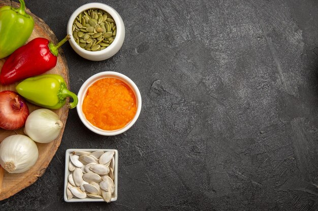 Vue de dessus des légumes frais avec des tranches de citrouille sur fond gris salade mûre de couleur fraîche