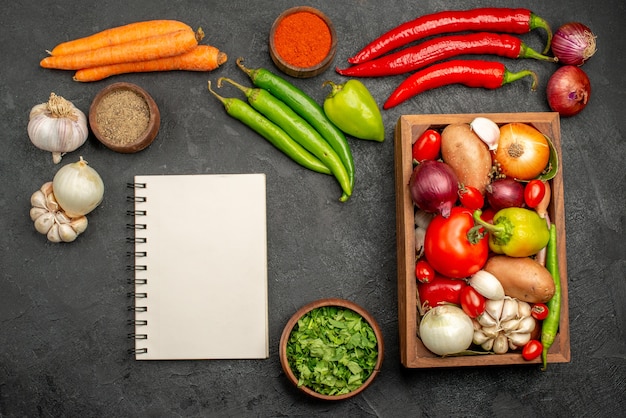 Vue de dessus des légumes frais avec des verts et de l'ail sur la santé de la couleur de la salade mûre bureau foncé