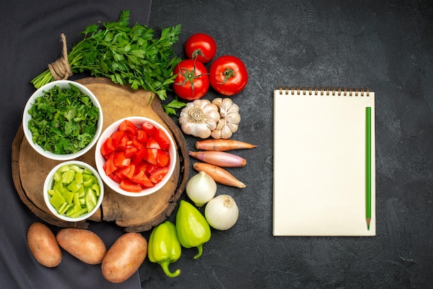 Vue de dessus des légumes frais avec des verts sur fond noir