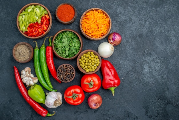 Vue de dessus des légumes frais avec des verts sur la table sombre salade de couleur fraîche de légumes mûrs