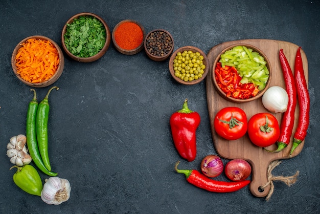 Photo gratuite vue de dessus des légumes frais avec des verts sur la table sombre salade de couleur végétale mûres