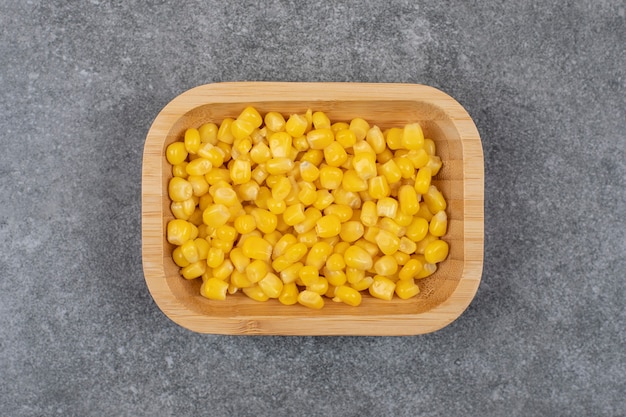 Vue de dessus de légumes sains. Graines de maïs en conserve dans un bol en bois